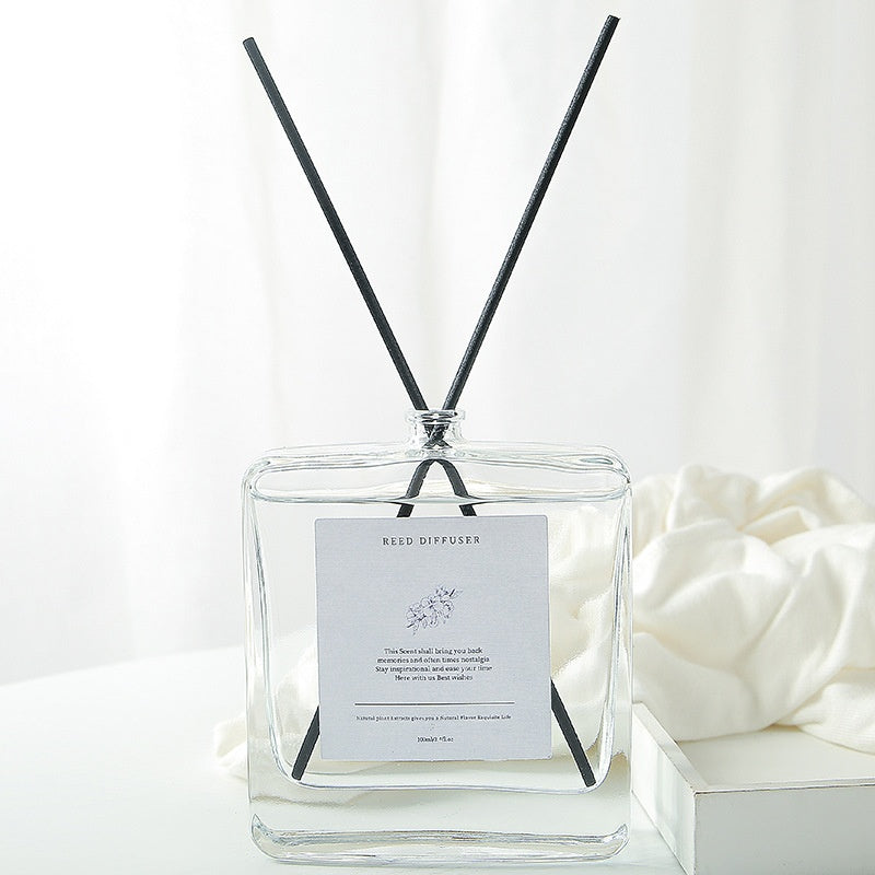 Minimalist Reed Diffuser — bottle with reeds beside white fabric