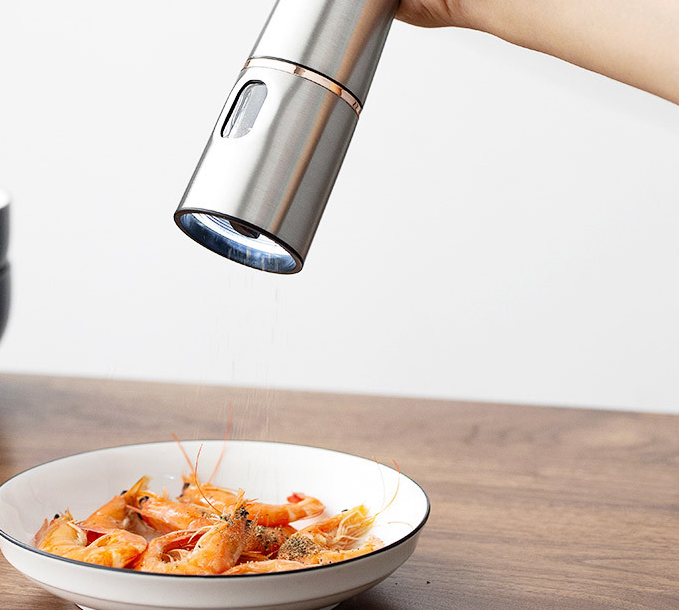 Electric Salt & Pepper Grinder — grinding over a dish with the base light on