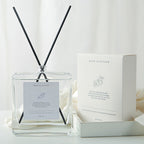 Minimalist Reed Diffuser — clear square glass bottle with black reeds beside its white gift box