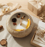 Coconut Shell Botanical Candle — on linen beside a kraft gift box