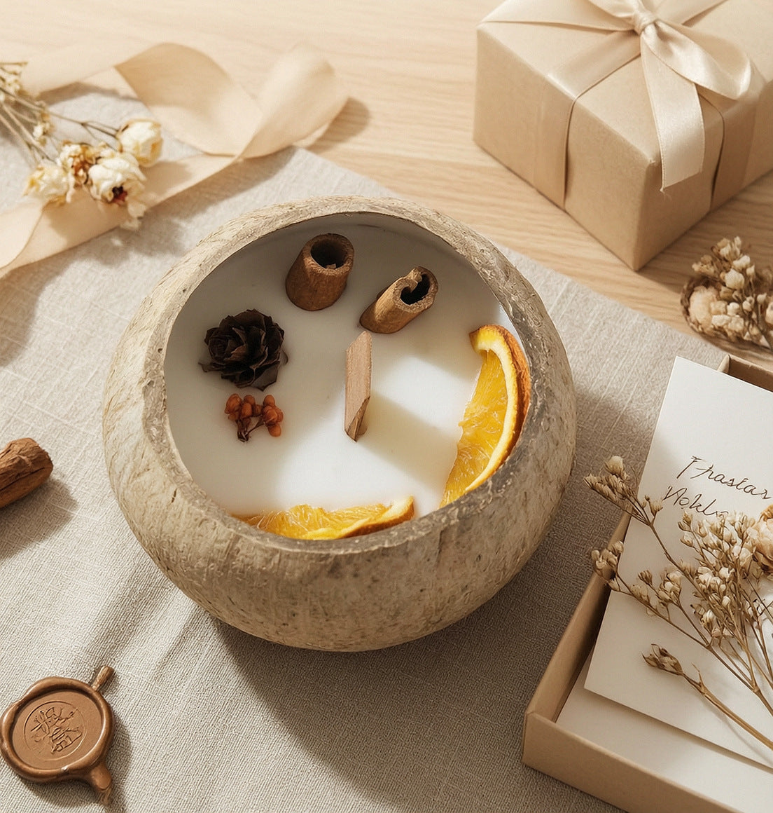 Coconut Shell Botanical Candle — on linen beside a kraft gift box
