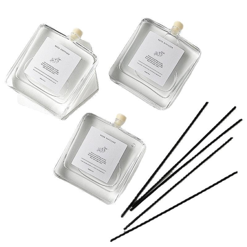 Minimalist Reed Diffuser — flat lay of bottles and black reeds
